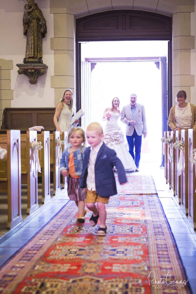 Kinderen lopen voor de bruid uit in de kerk